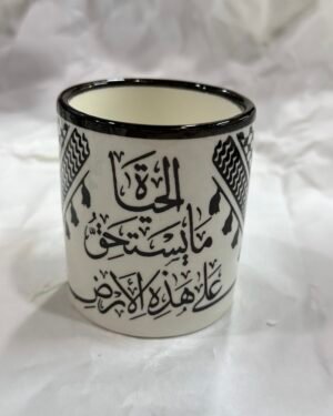 كوب خزف مزخرف بعبارة (علَى هَذِهِ الأَرْض مَا يَسْتَحِقُّ الحَياةْ)